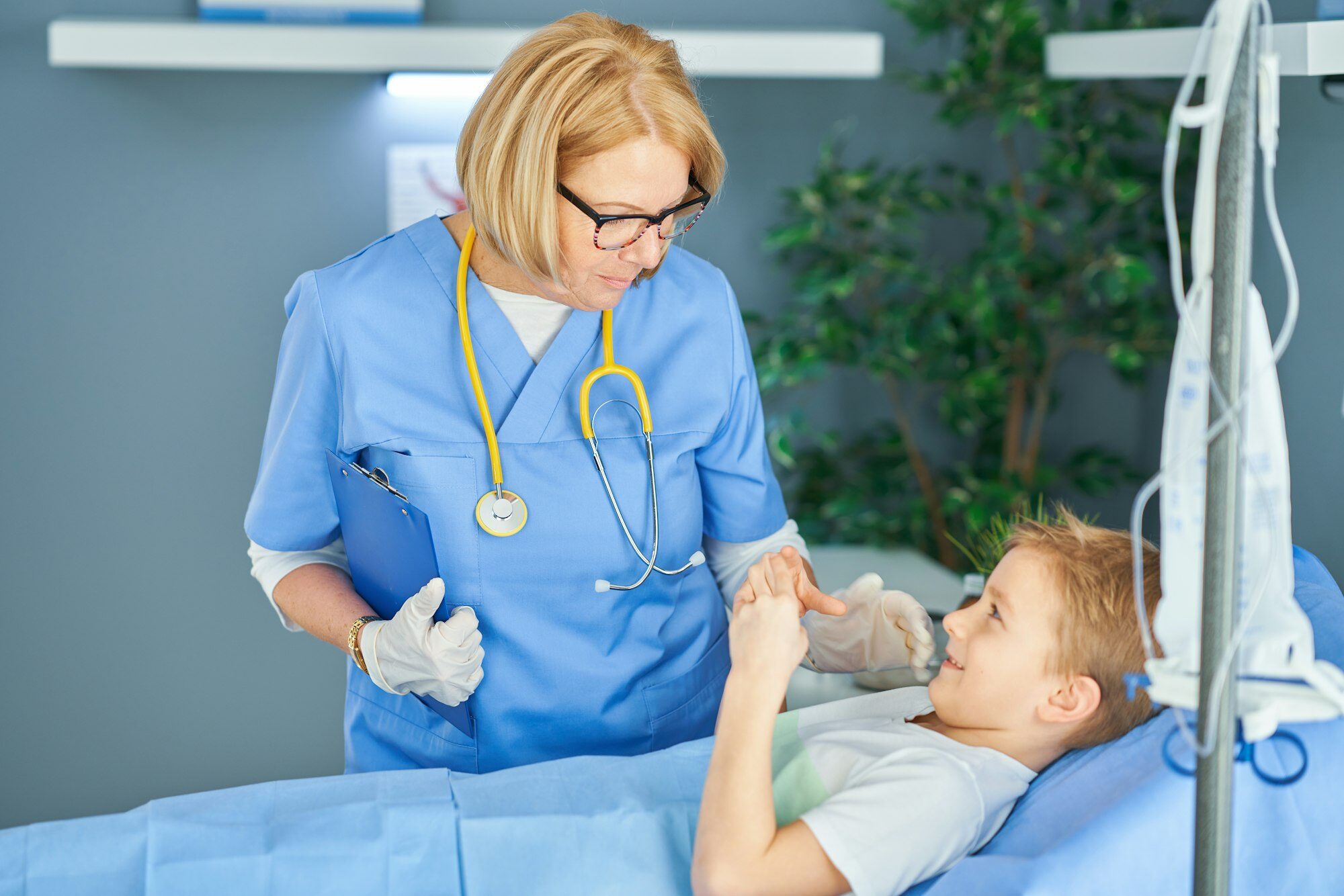 Adult woman and young patient in hospital bed